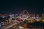 a night view of a city with a roller coaster