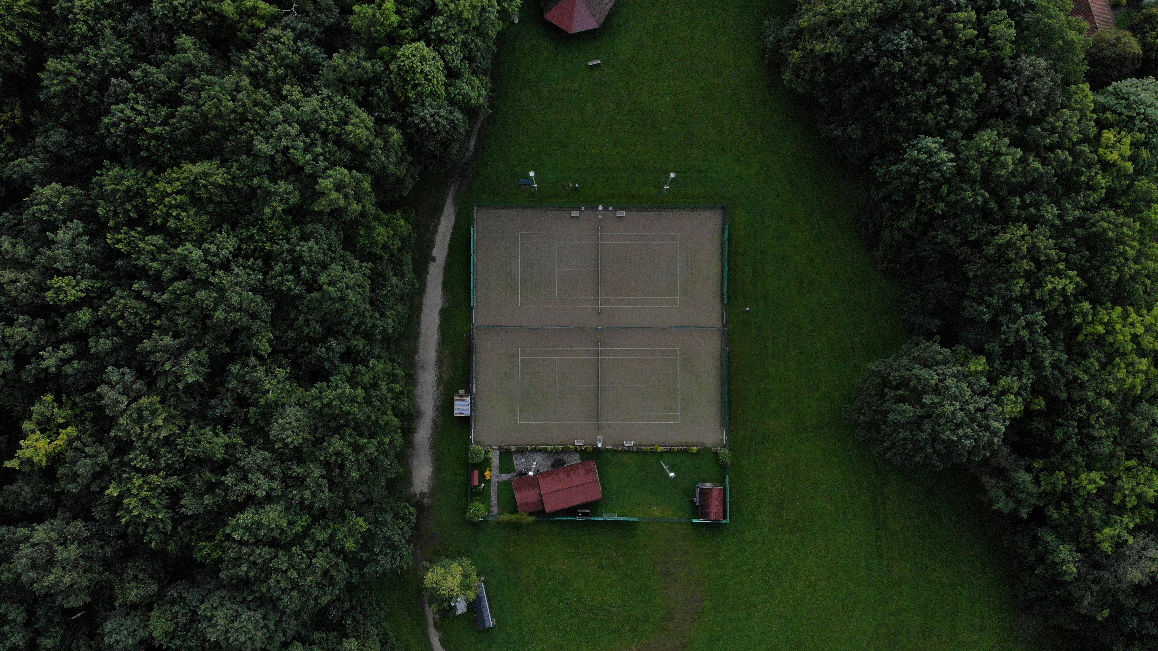 an aerial view of a tennis court surrounded by trees