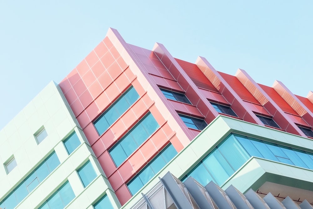 a red and green building with a blue sky in the background