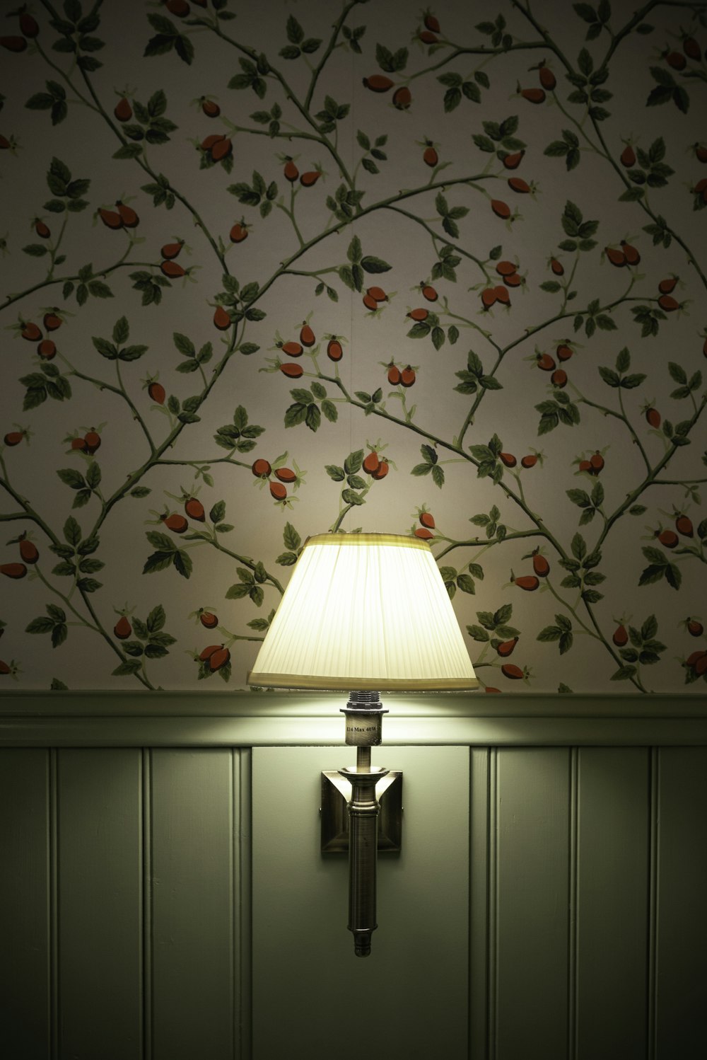 a lamp on a wall next to a wallpapered wall