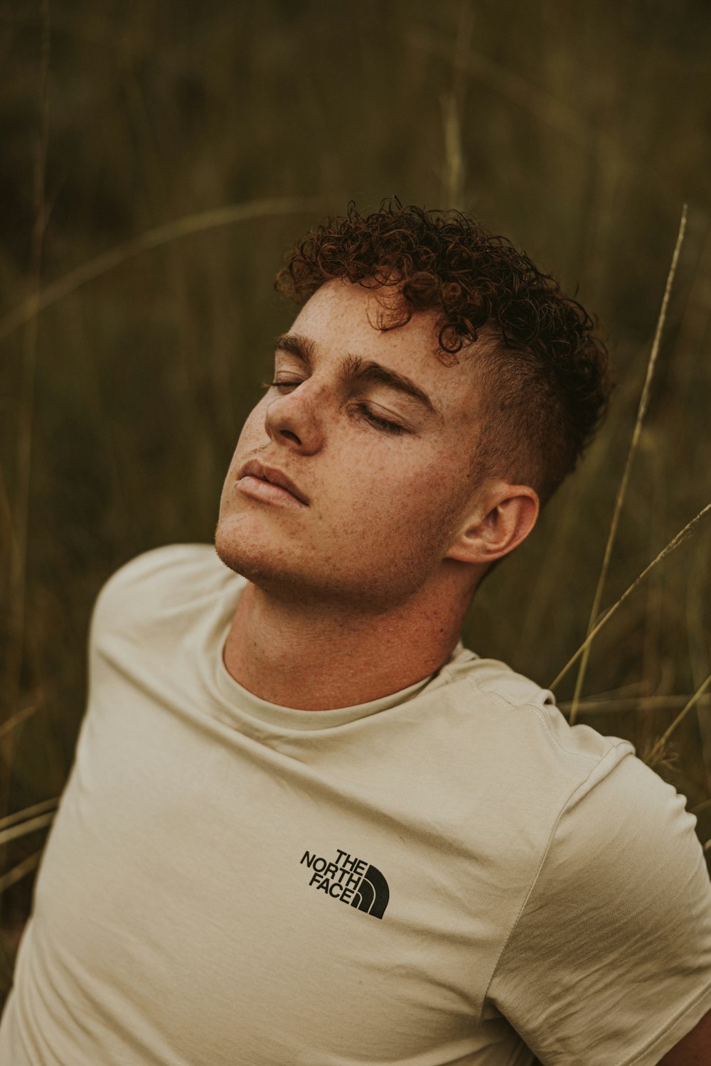 a man sitting in a field with his eyes closed