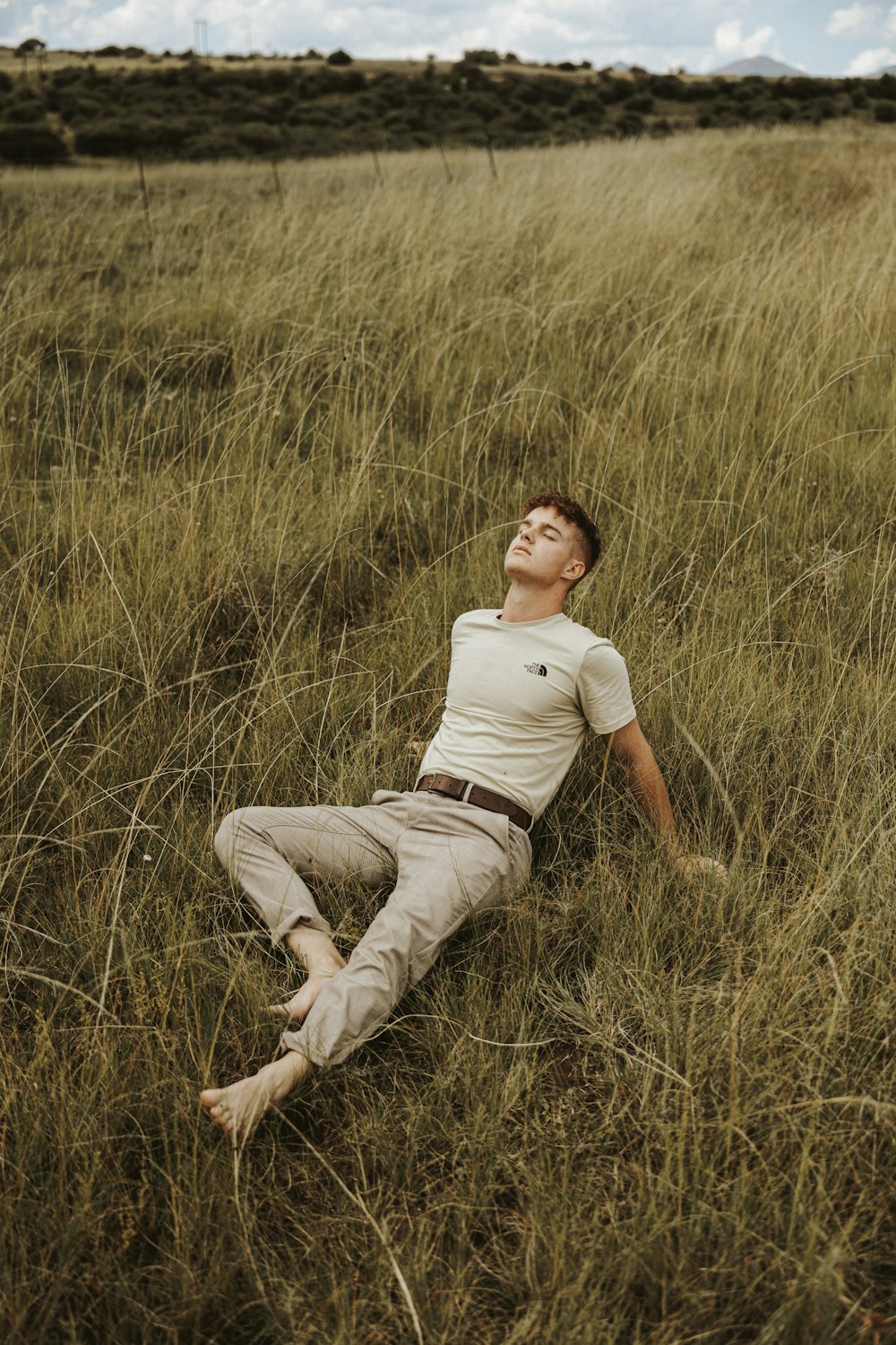 a man laying in a field of tall grass