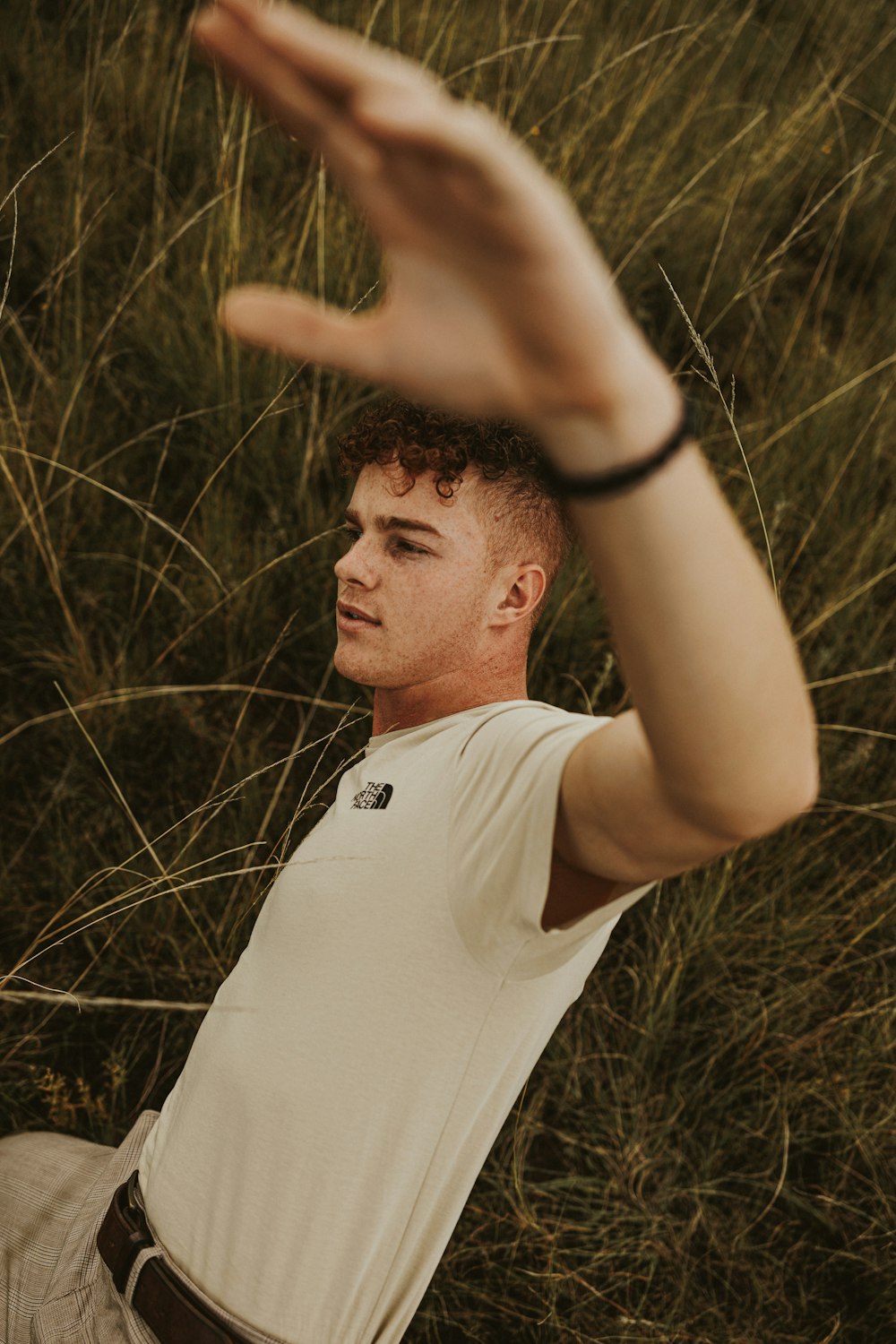 a man sitting in a field of tall grass