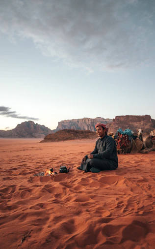 a man sitting in the middle of a desert