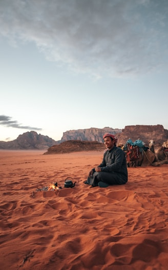 a man sitting in the middle of a desert