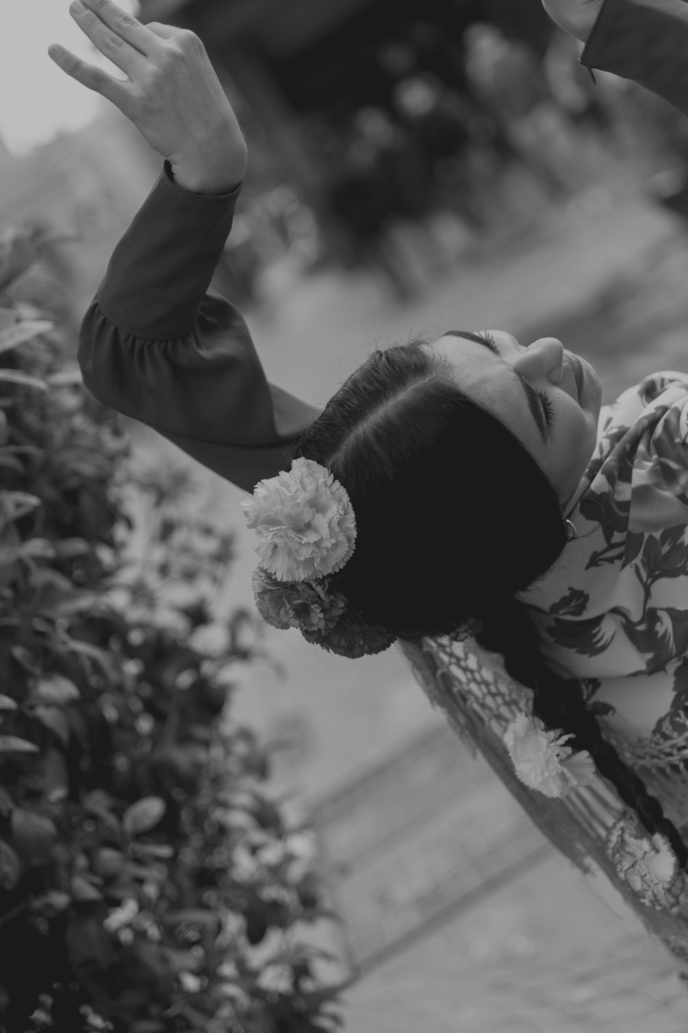 a woman laying in a hammock with her hands in the air