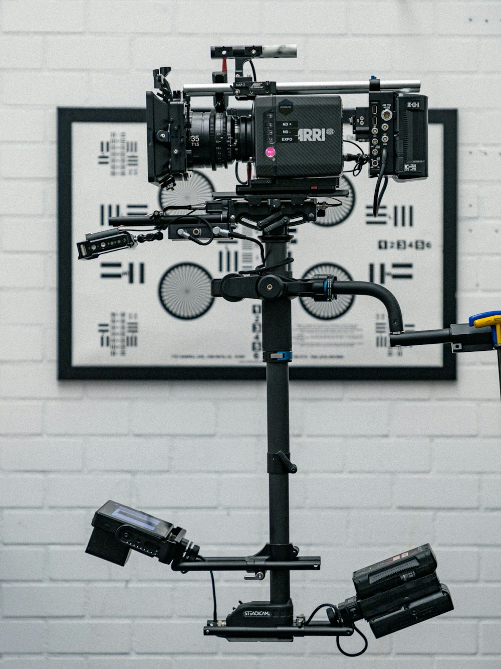 a camera set up on a tripod in front of a white brick wall