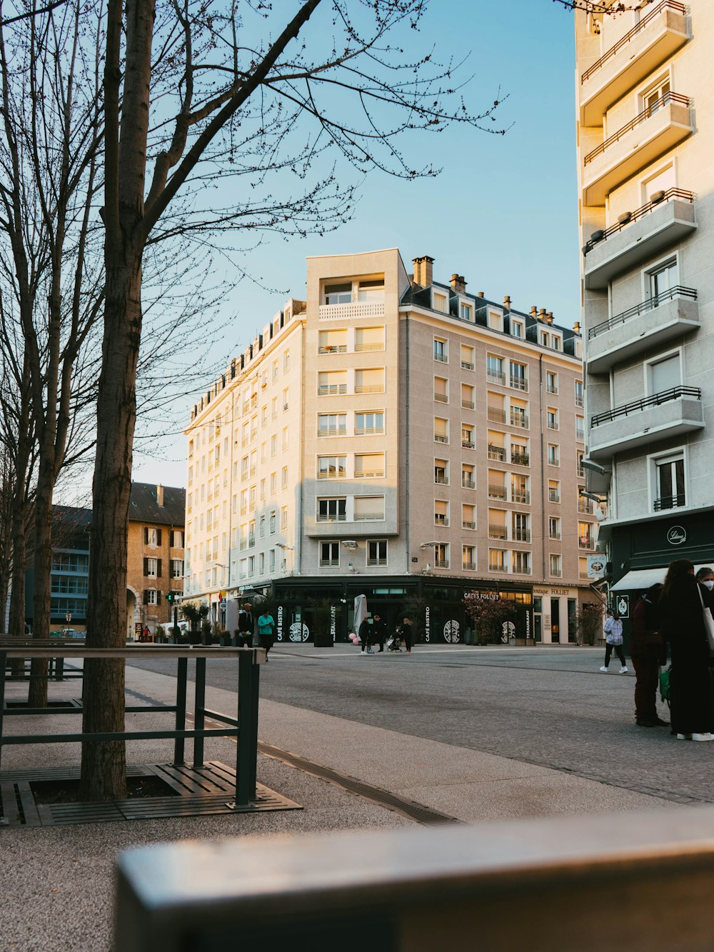 a group of people walking down a street next to tall buildings