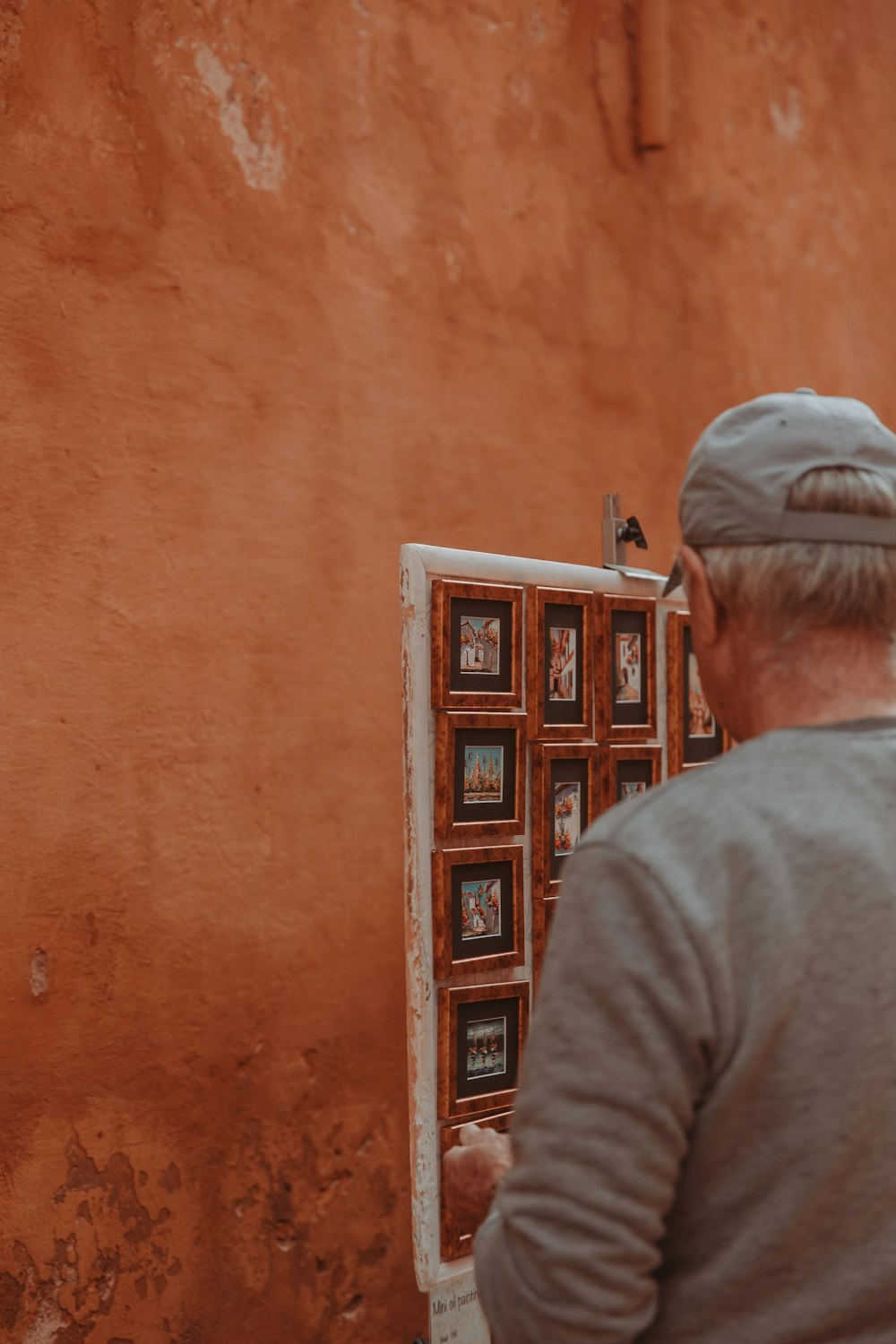 a man standing in front of a mirror with pictures on it