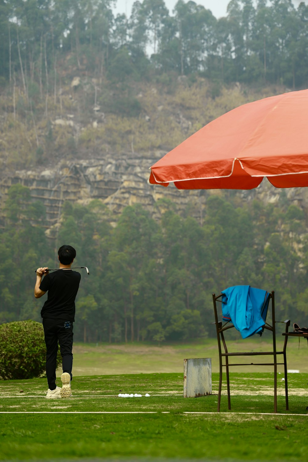 a man taking a picture of a chair and umbrella