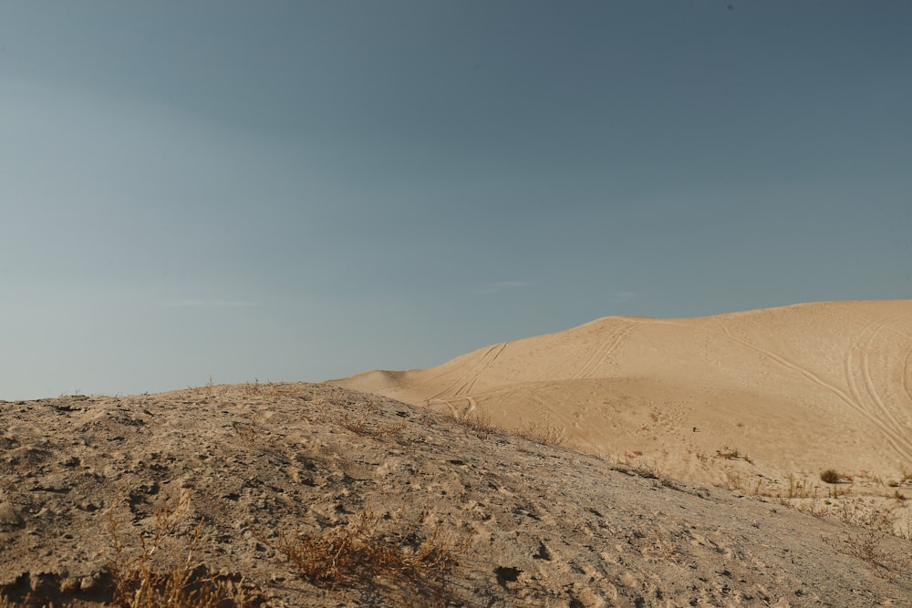 a hill of sand with a blue sky in the background