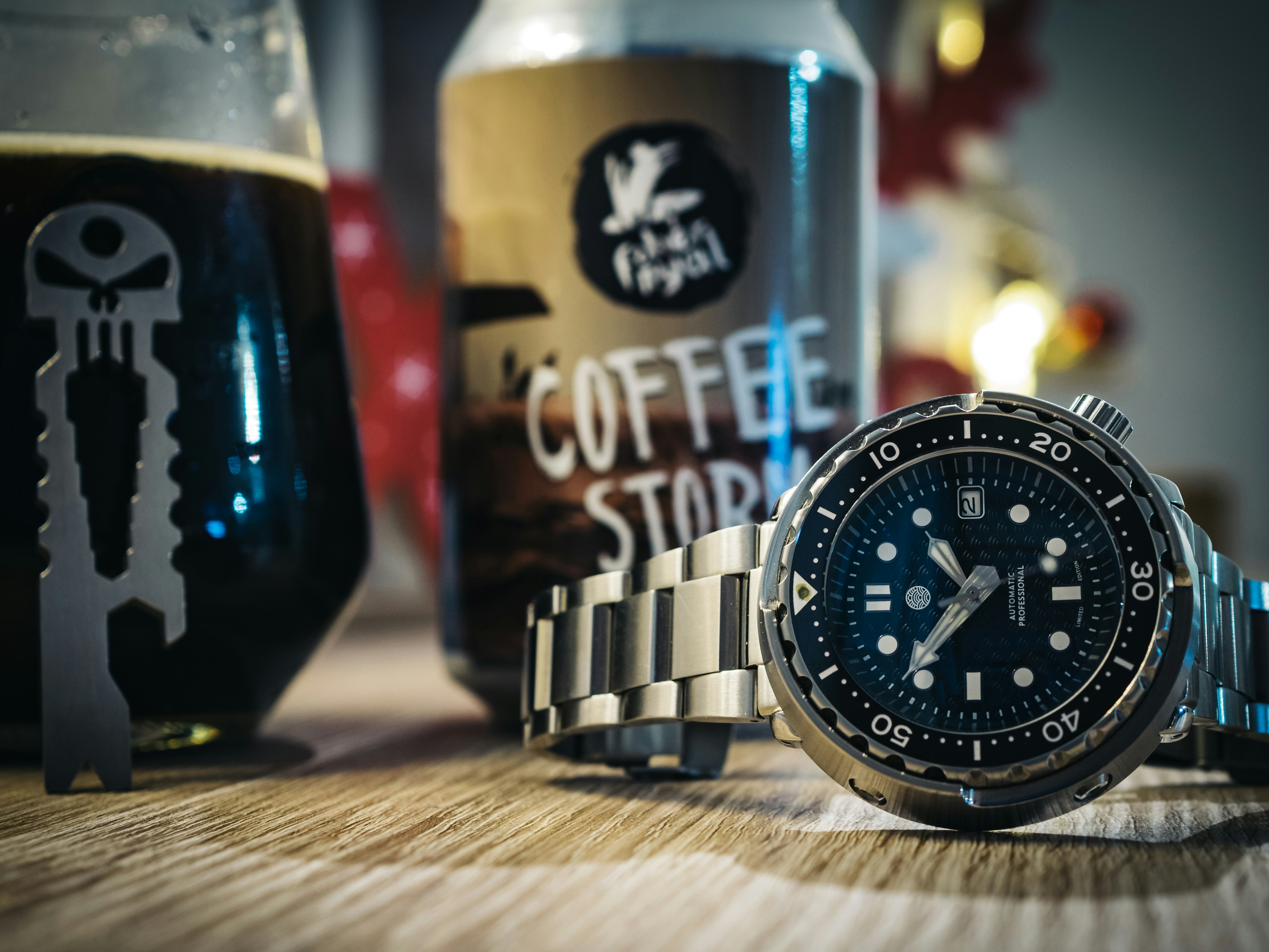 a watch sitting on top of a table next to a bottle of beer