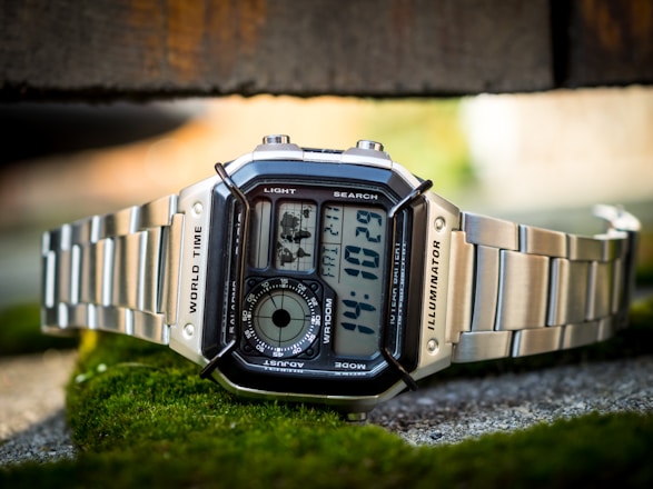 a close up of a watch on a mossy surface