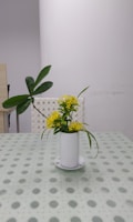 A contemporary cylindrical vase with fresh flowers on a table.