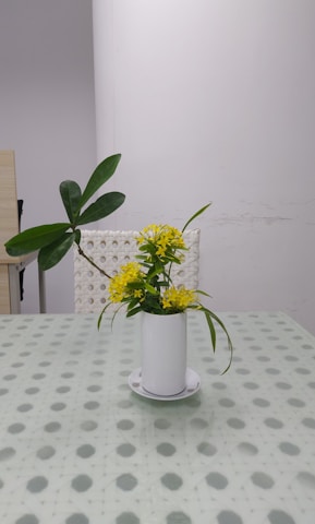 A contemporary cylindrical vase with fresh flowers on a table.