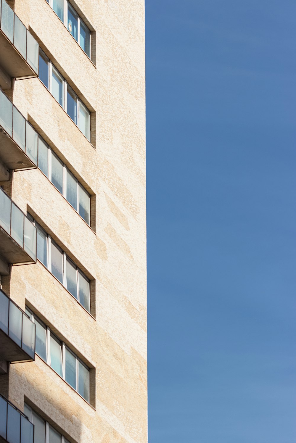 a tall building with windows and a sky background