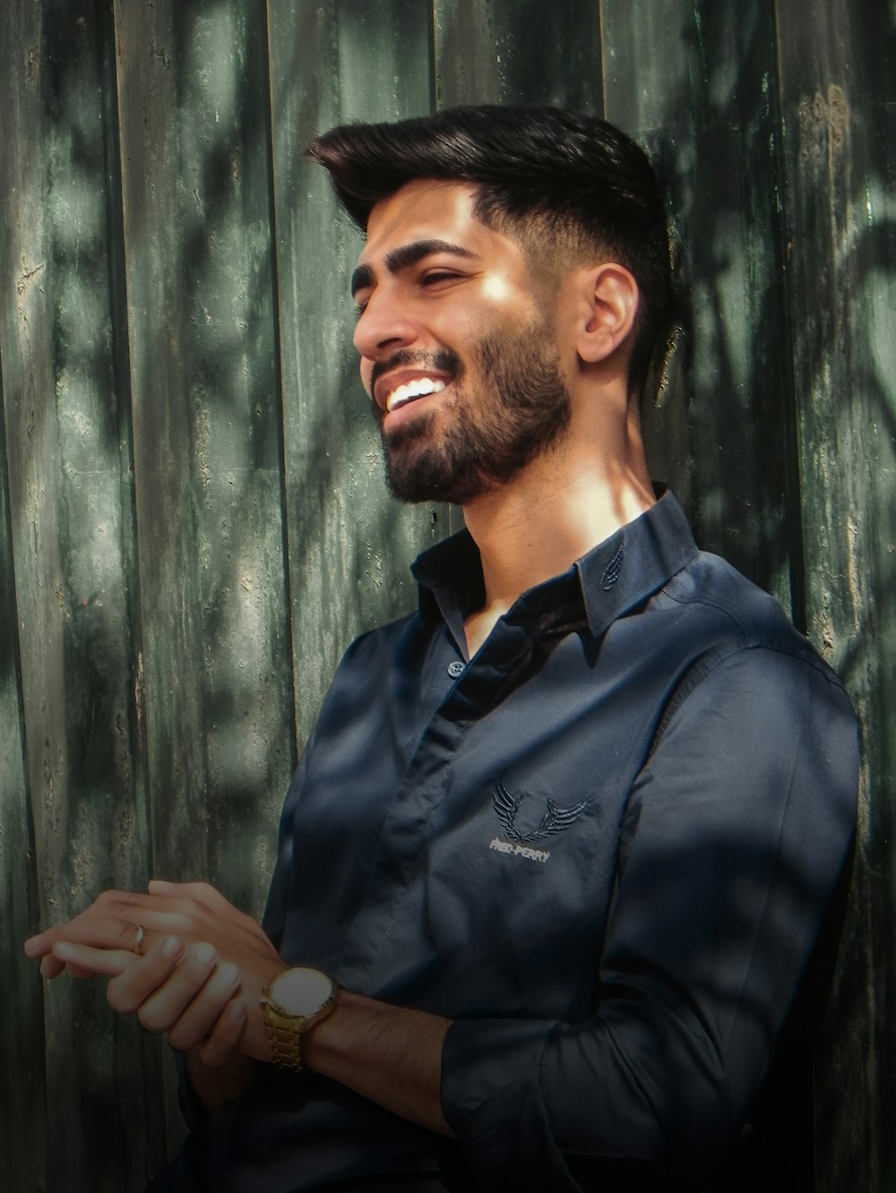 a man standing in front of a wooden fence