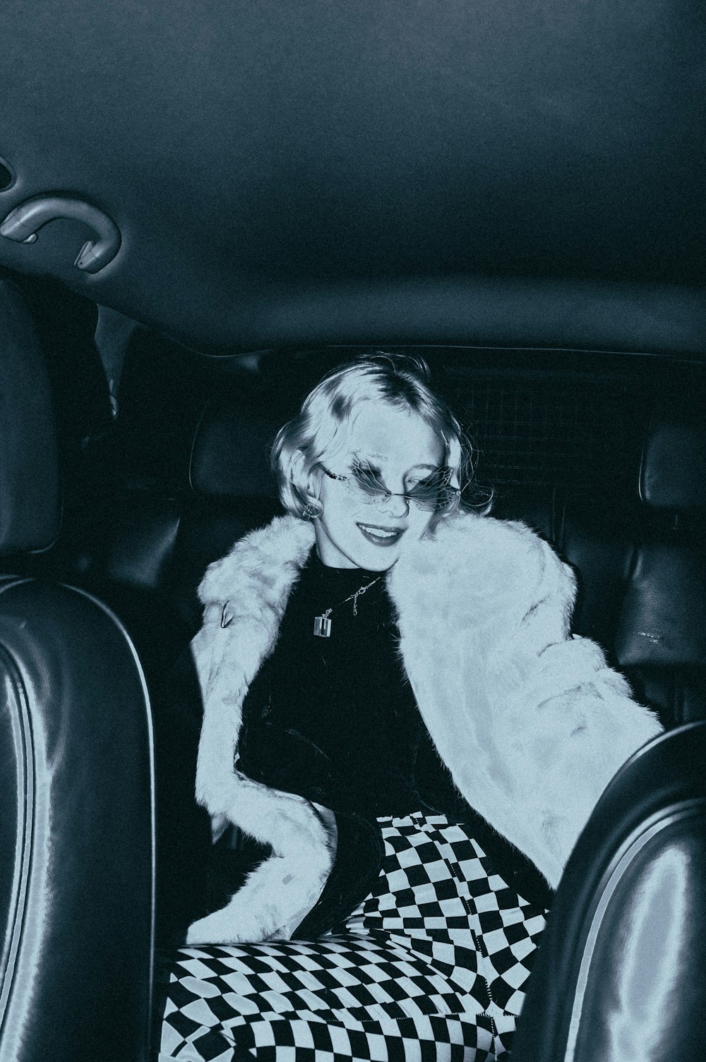 a black and white photo of a woman in a car