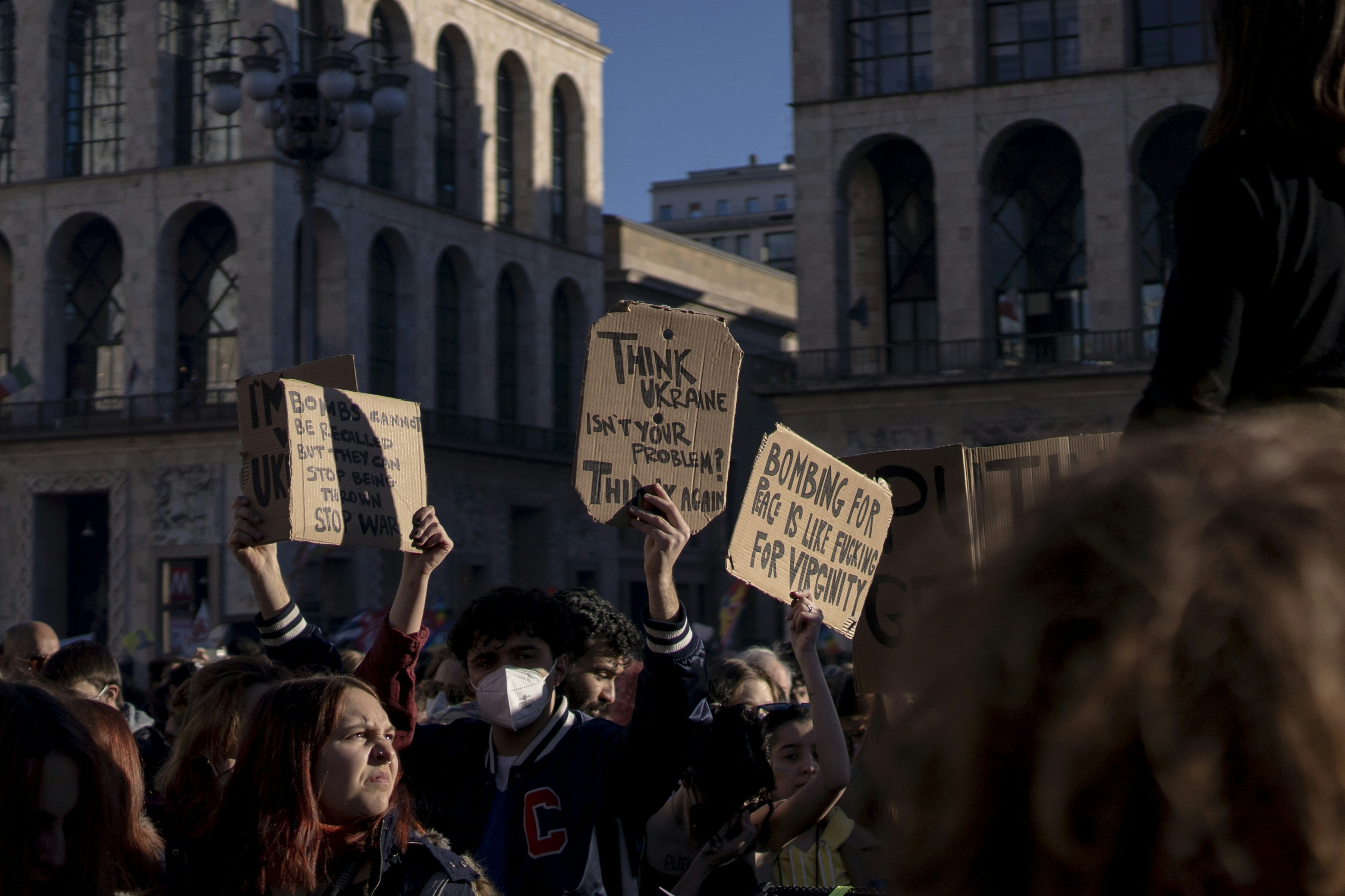 a group of people holding signs in front of a building