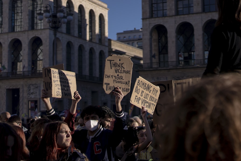 a group of people holding signs in front of a building