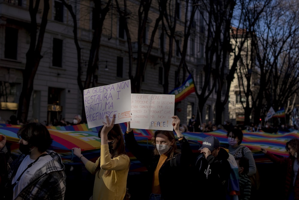 a group of people holding signs in front of a building