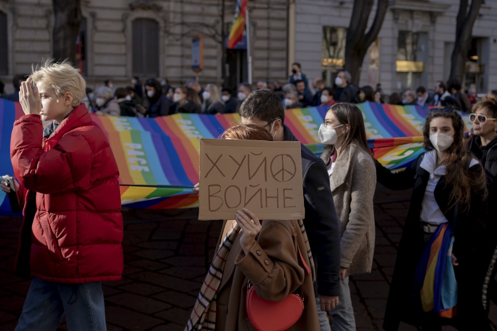 a group of people holding a sign in front of a building