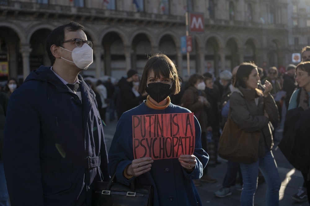 a group of people standing around each other holding signs