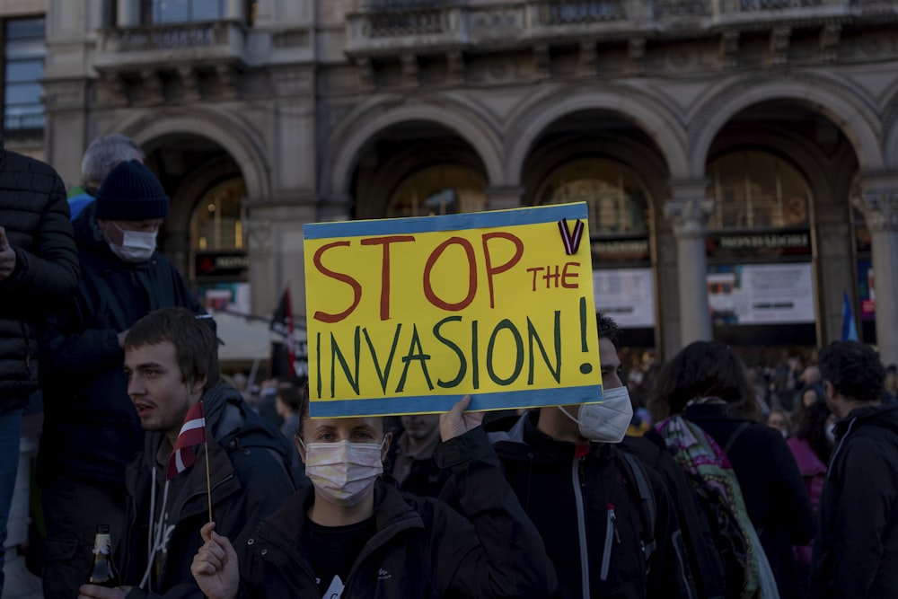 a group of people standing around each other holding signs