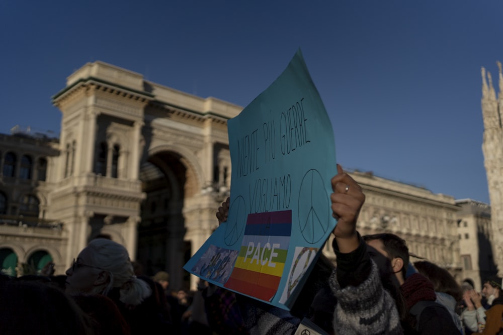 a person holding a sign in front of a building