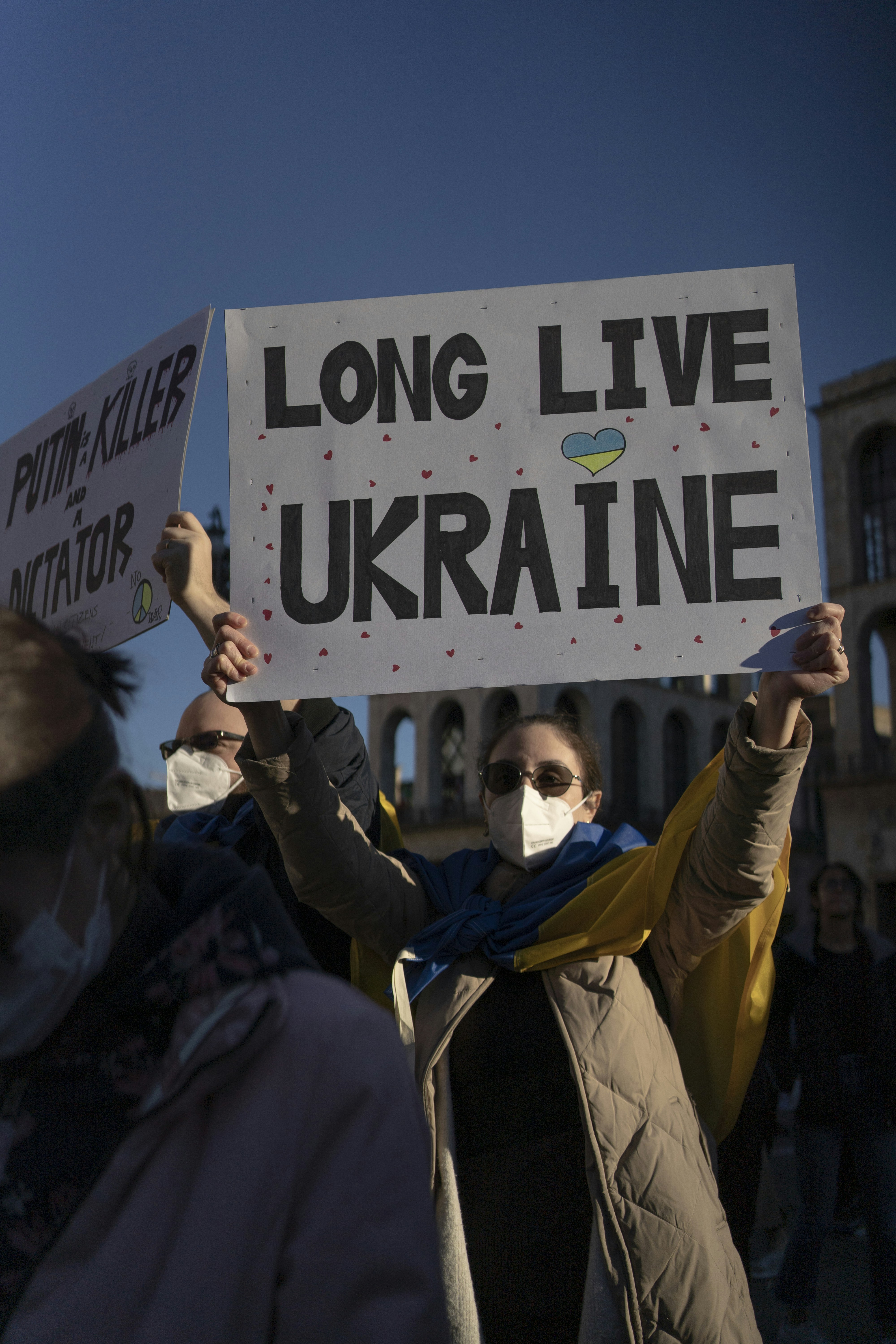 a group of people holding up signs in front of a building