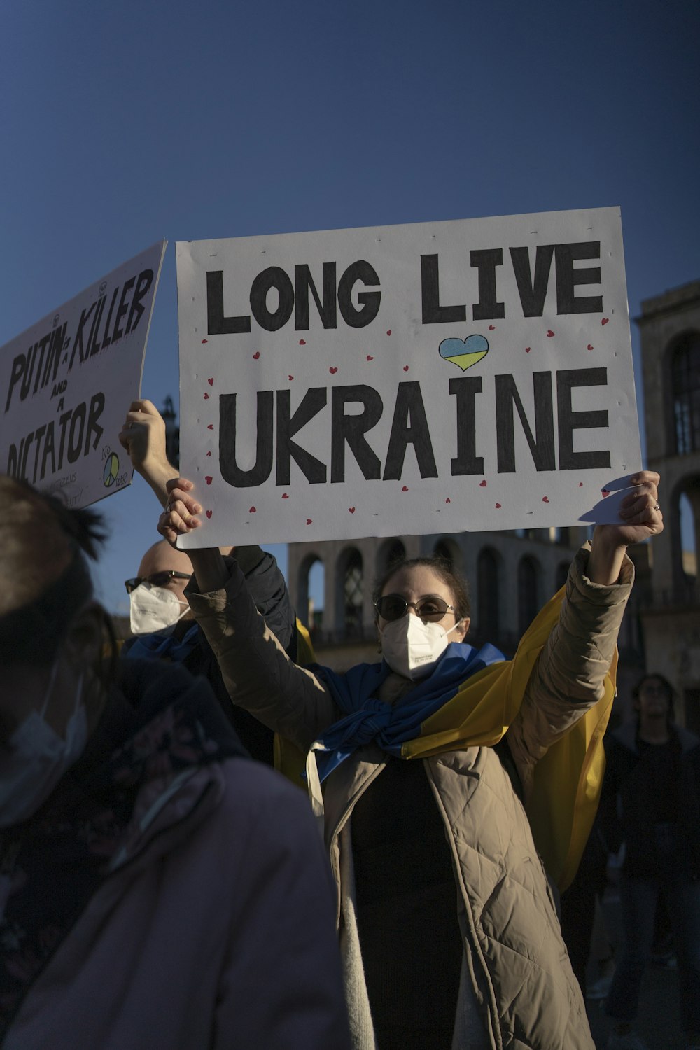 a group of people holding up signs in front of a building