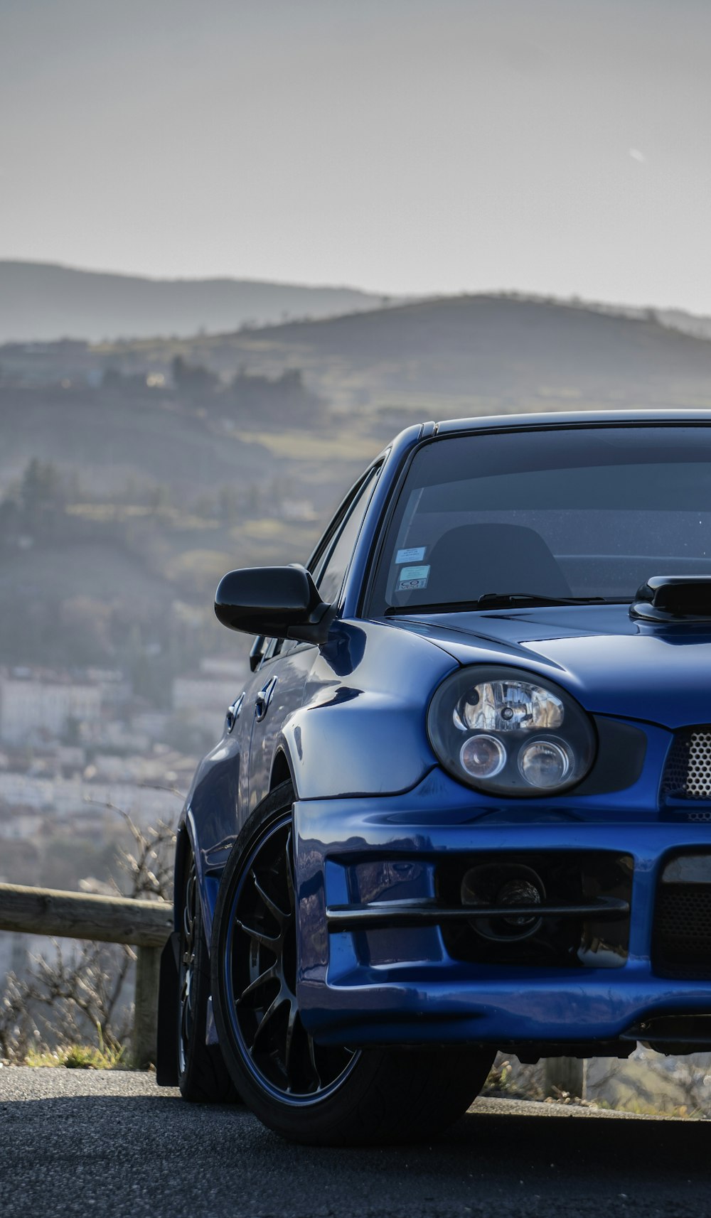 a blue car parked on the side of a road