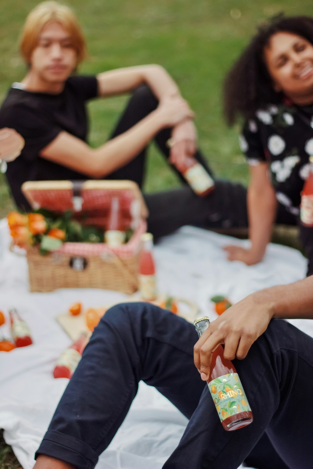 a group of people sitting on top of a grass covered field