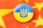 A round badge featuring the blue and yellow flag of Ukraine with the national coat of arms is placed on a red fabric decorated with yellow stars.