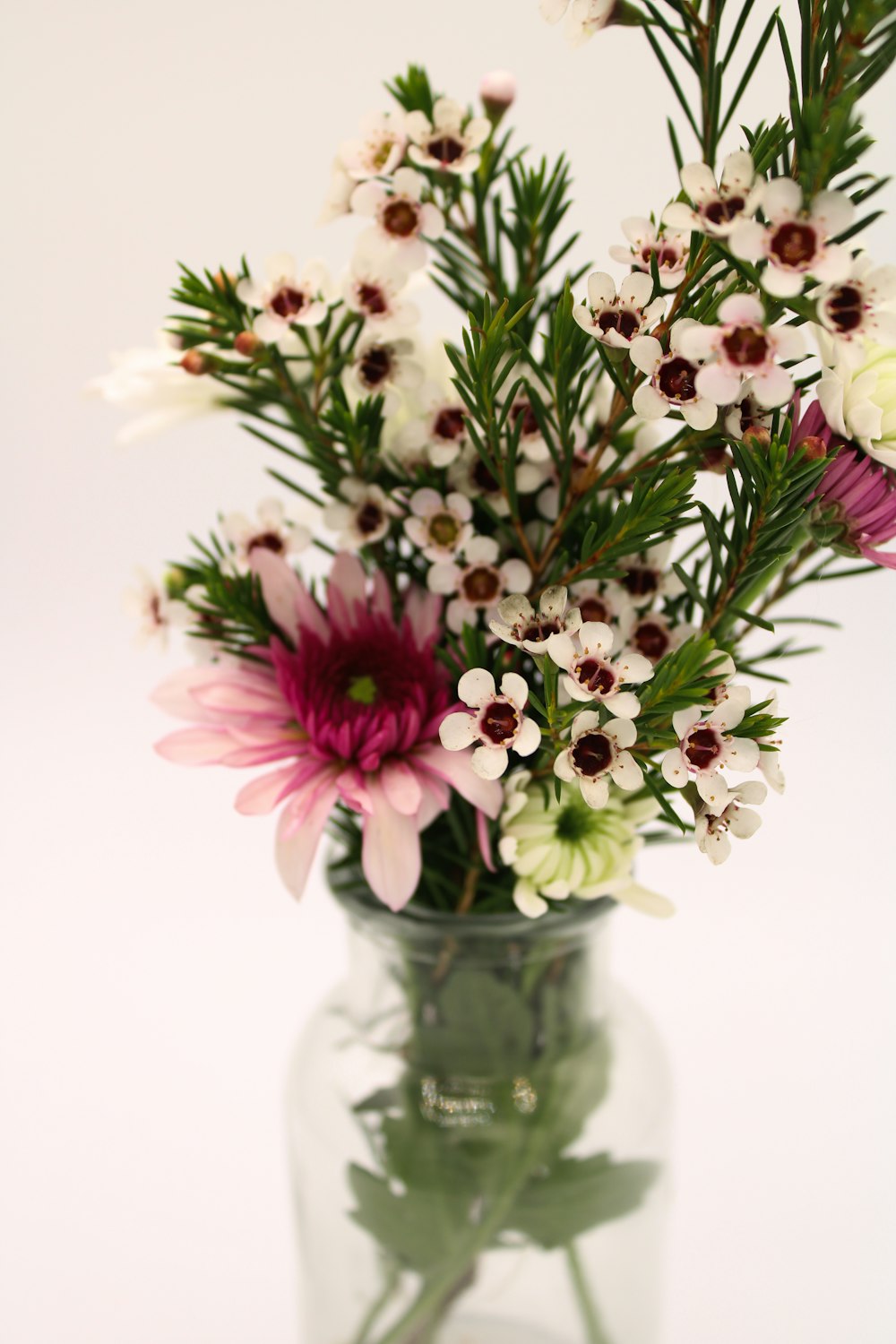 a vase filled with lots of flowers on top of a table