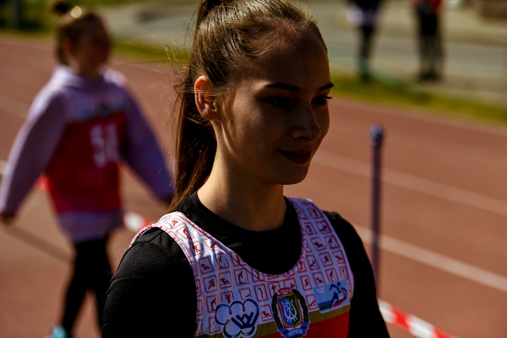 a woman standing next to a pole on a track