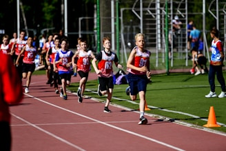 a group of young people running on a track