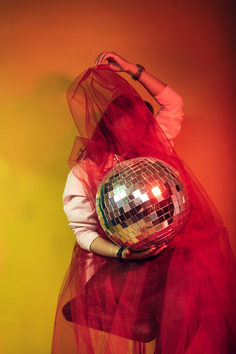 a woman in a red dress holding a disco ball
