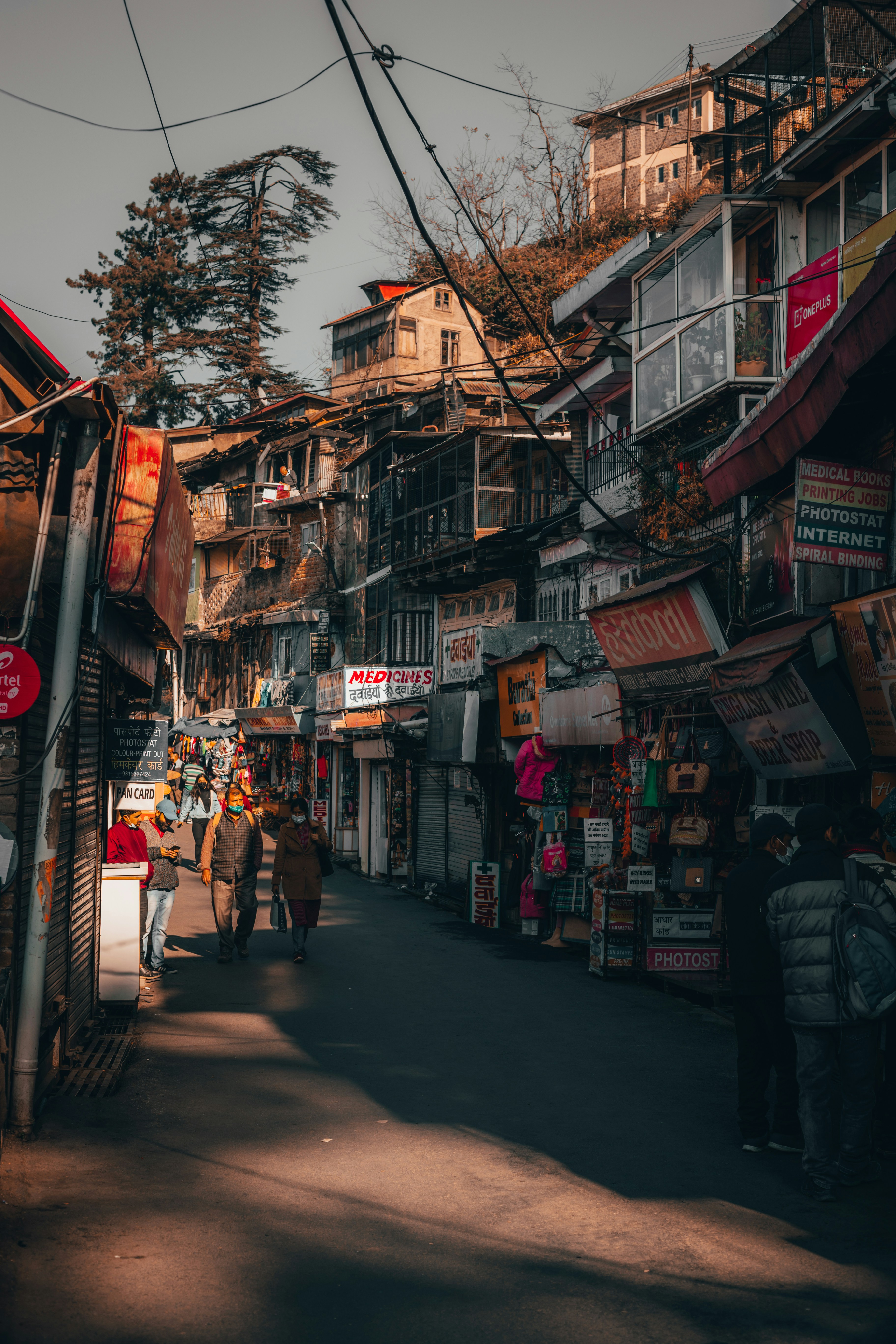 a group of people walking down a street next to tall buildings