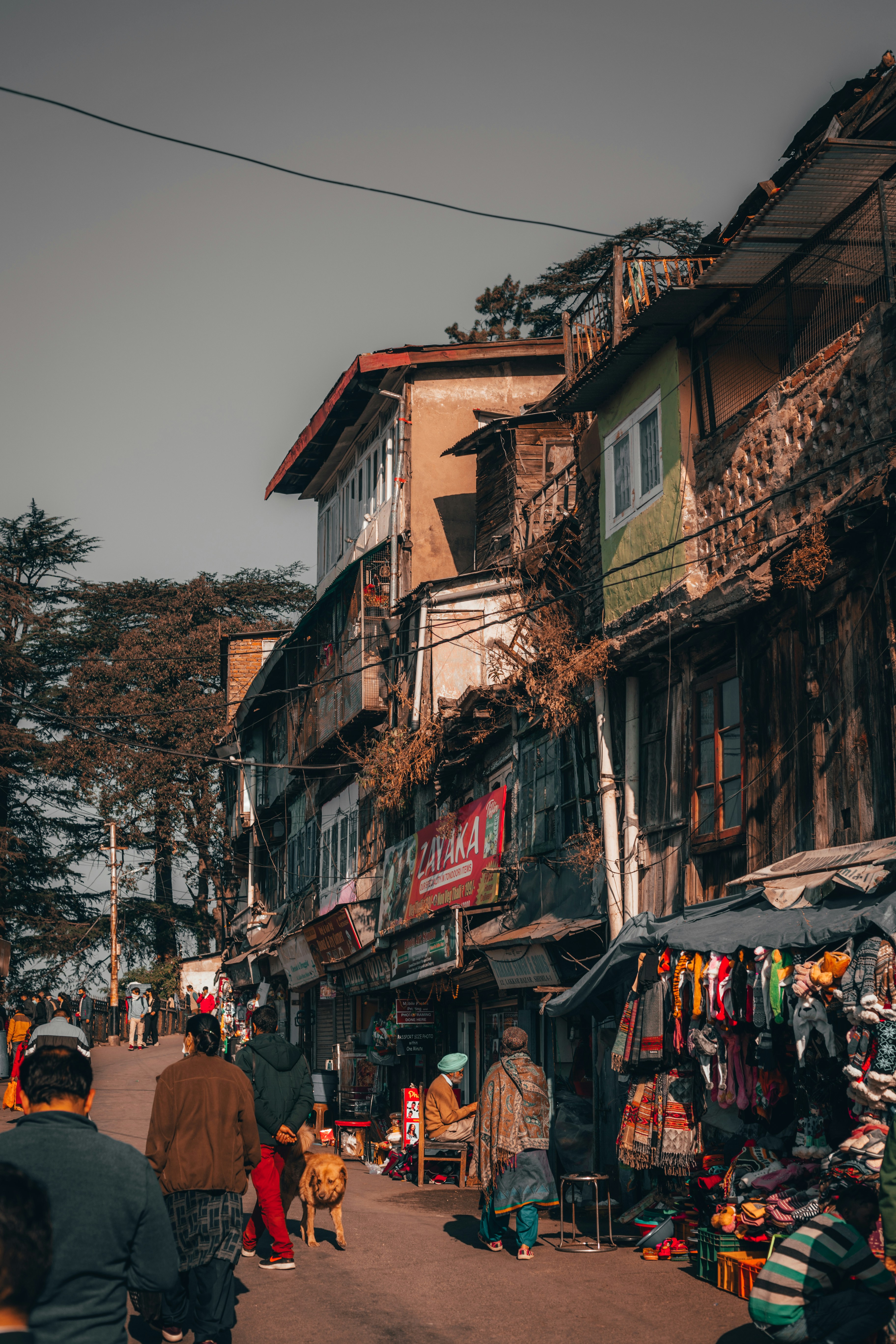 a group of people walking down a street next to tall buildings