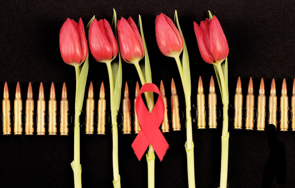 a group of flowers with a red ribbon on them