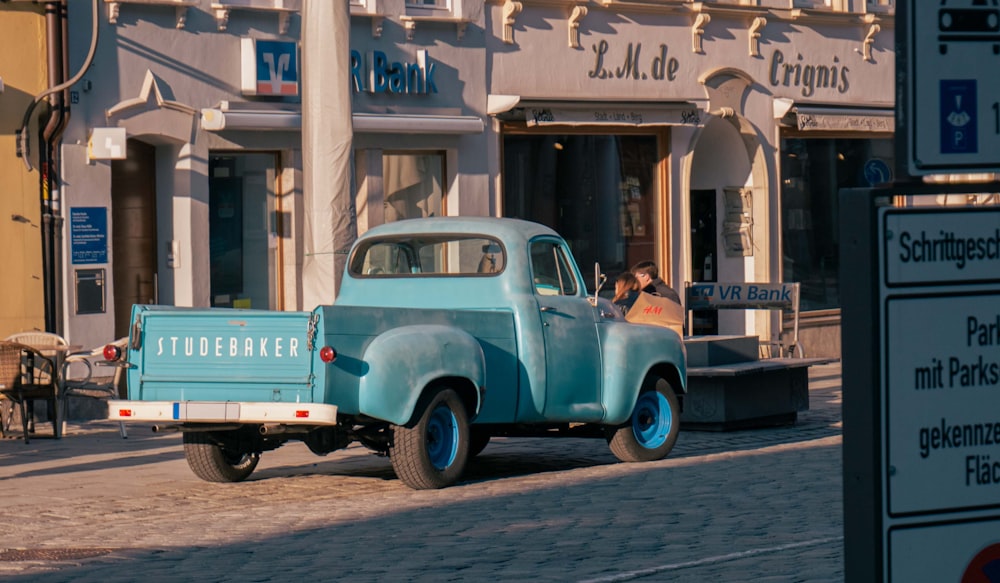 a blue truck parked on the side of a road