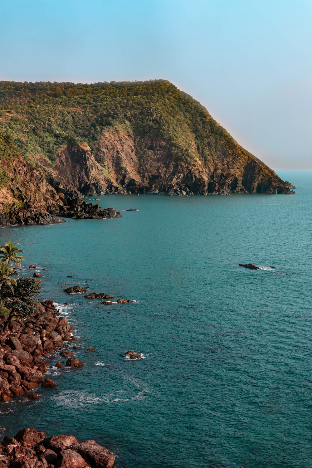 um grande corpo de água cercado por uma encosta verde exuberante