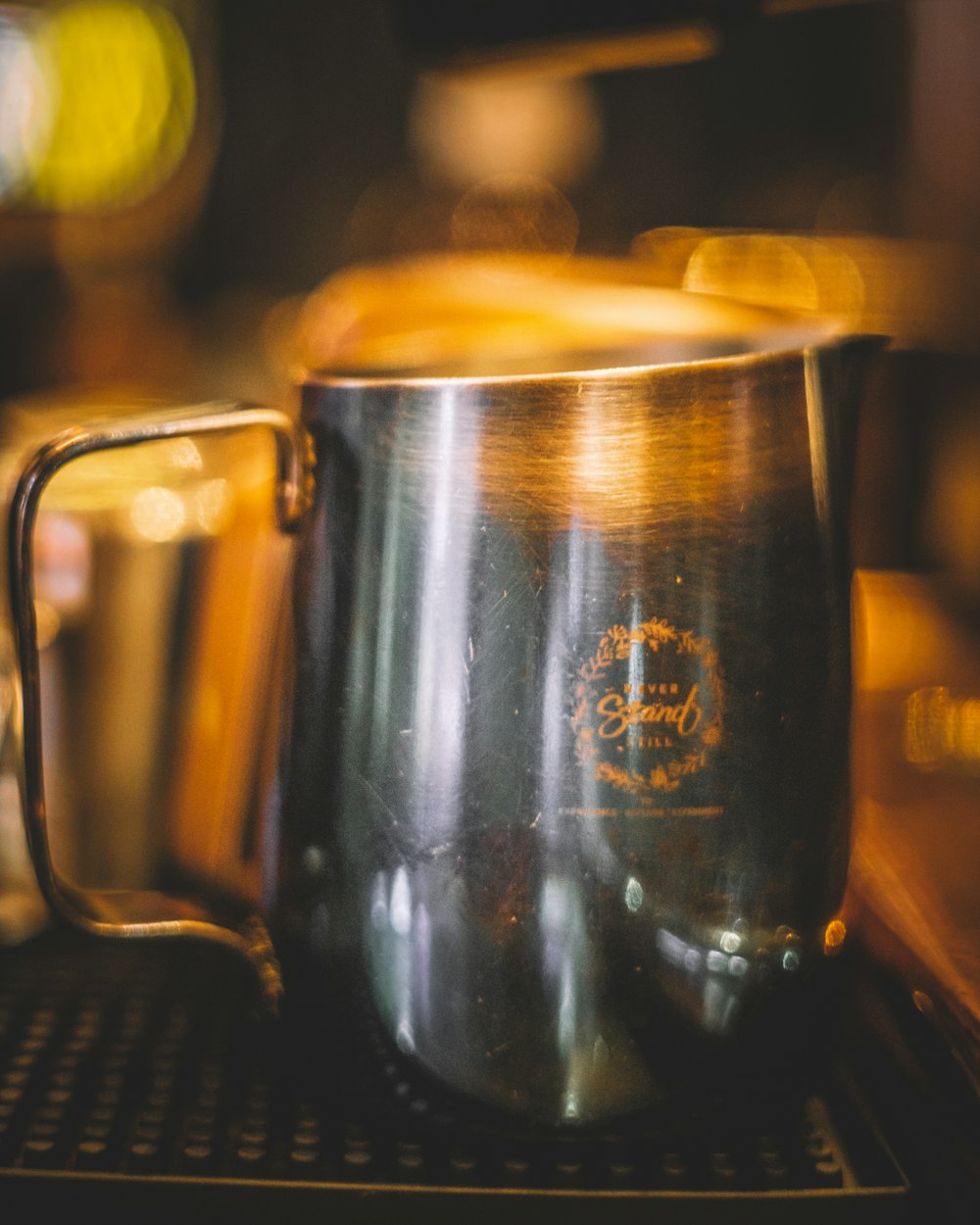 a metal cup sitting on top of a stove