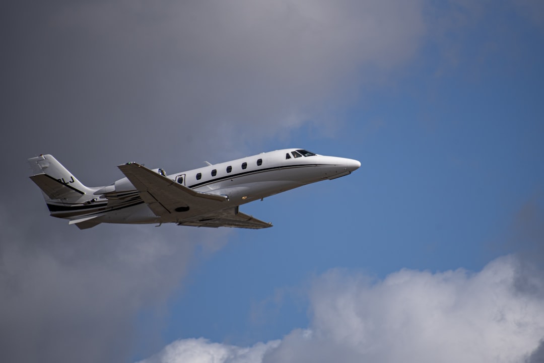 a small plane flying through a cloudy blue sky,