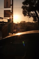 Evening light casting long shadows over a car being fixed outdoors, capturing the dedication behind the service.