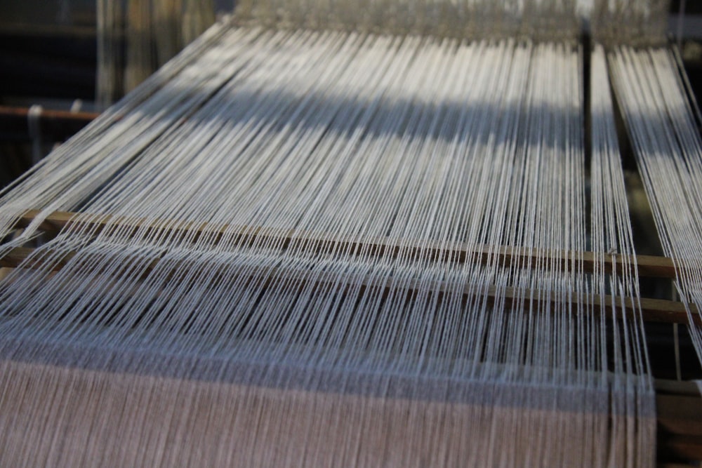 a close up of a weaving machine with yarn