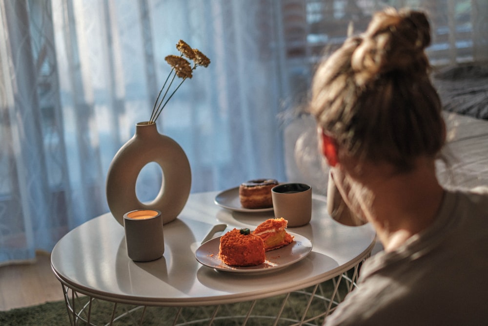 a woman sitting at a table with a plate of food