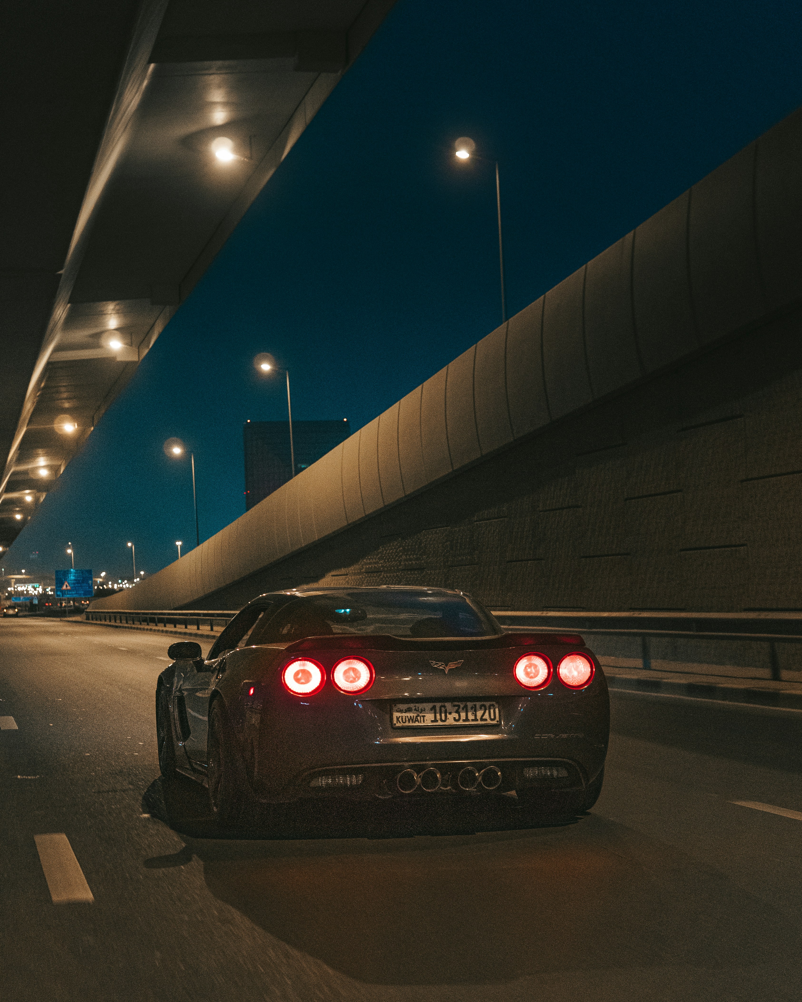 a black sports car driving down a highway at night
