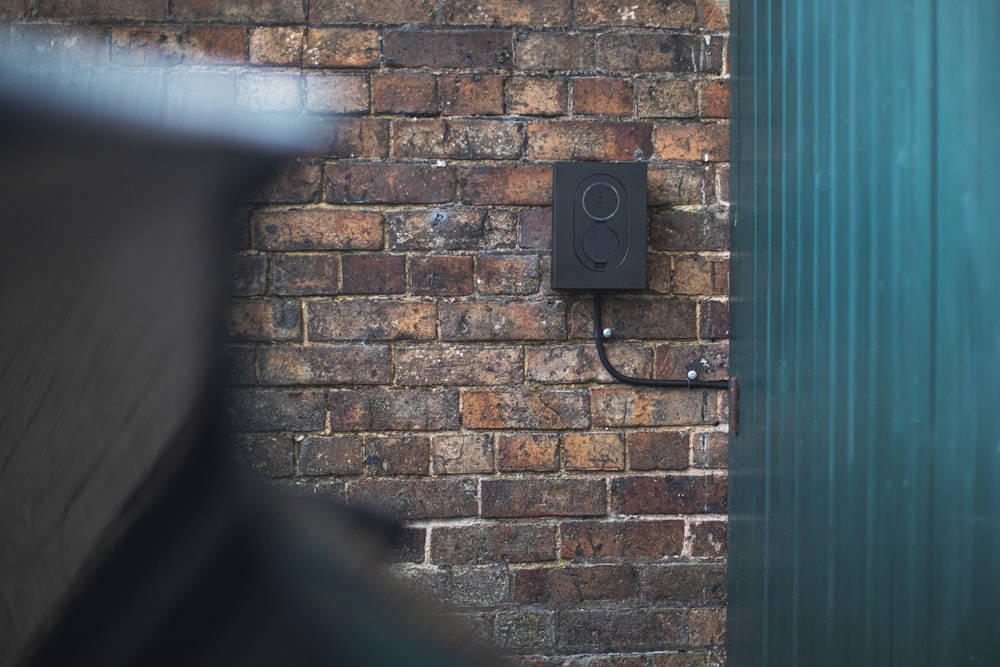 a brick wall with a black light switch on it